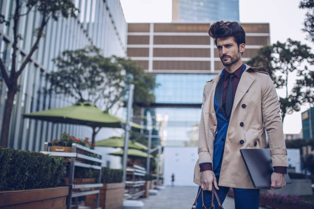 Well-dressed man wearing a tailored suit standing confidently in a modern, stylish interior with soft lighting and a calm, professional atmosphere